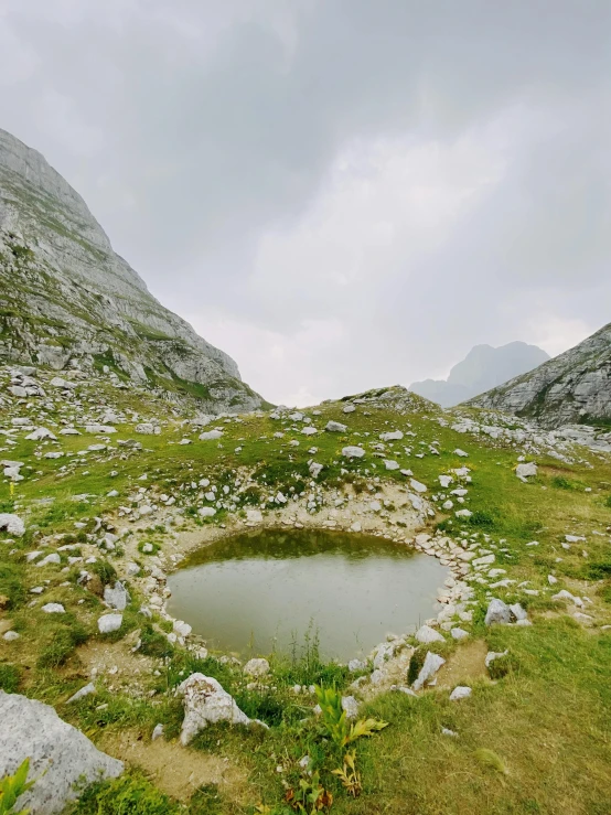 a small lake in between the mountains with rocks