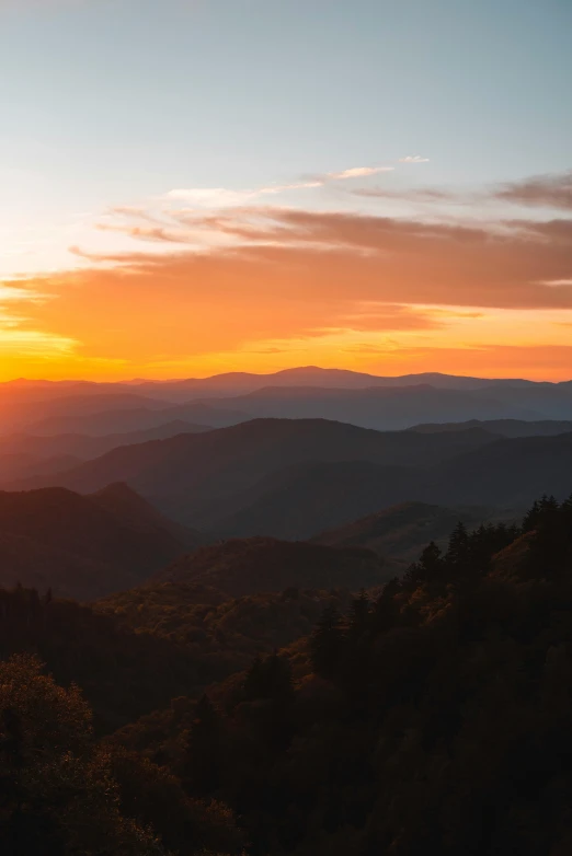 the sun rising over the mountains with mountains in the distance