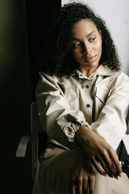 an african american woman poses in a white blazer jacket