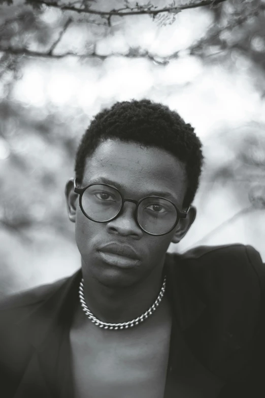 black man with black glasses in a black suit