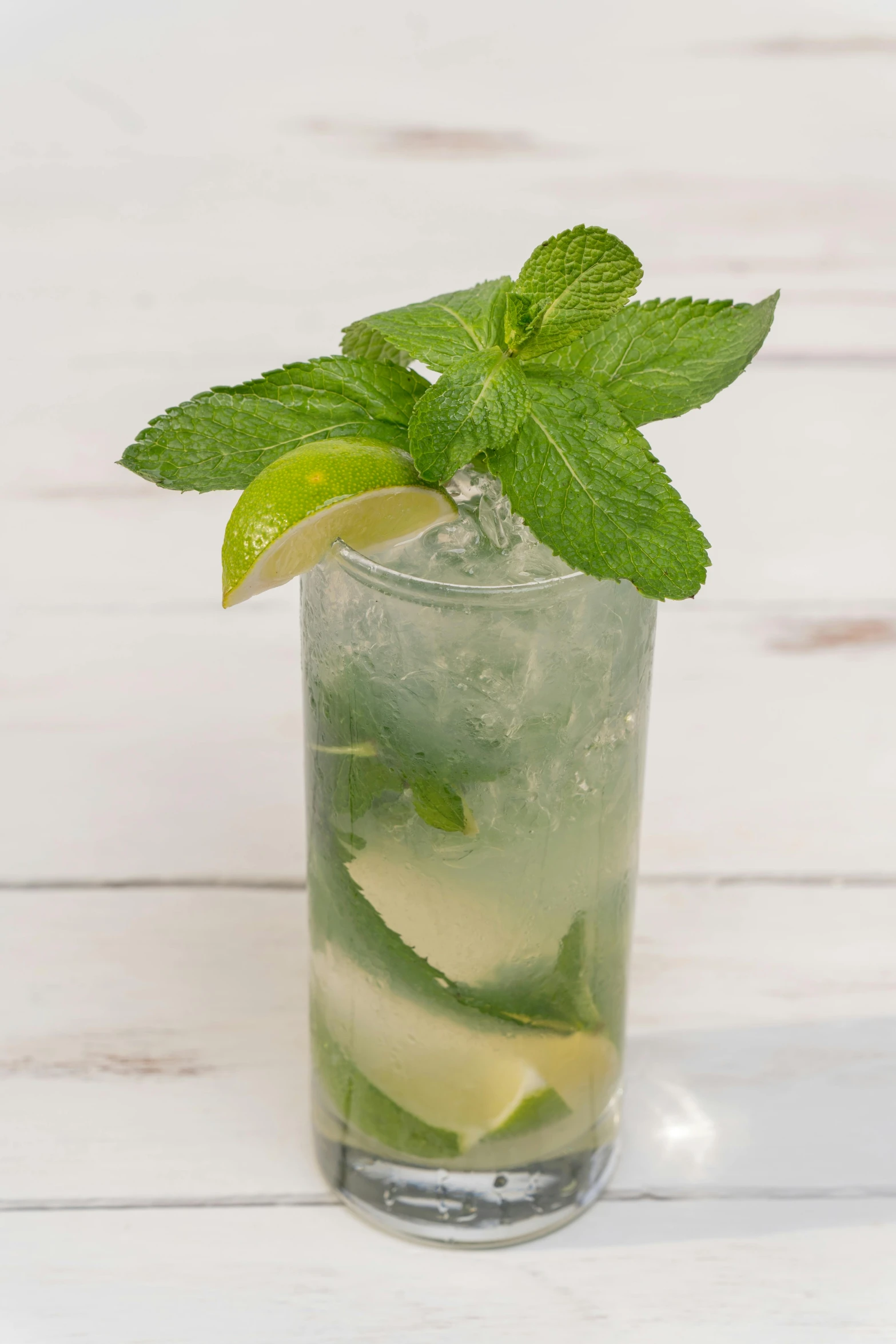 a green drink with ice, mint and lime