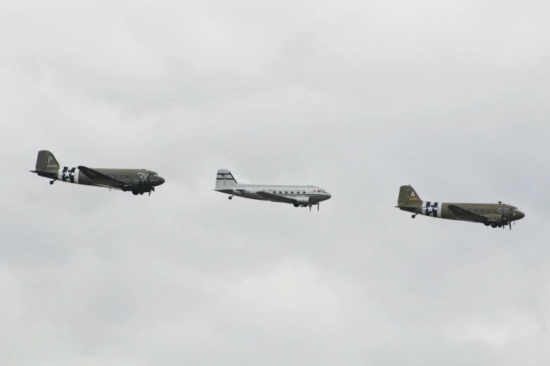 three old style airplanes flying in the air