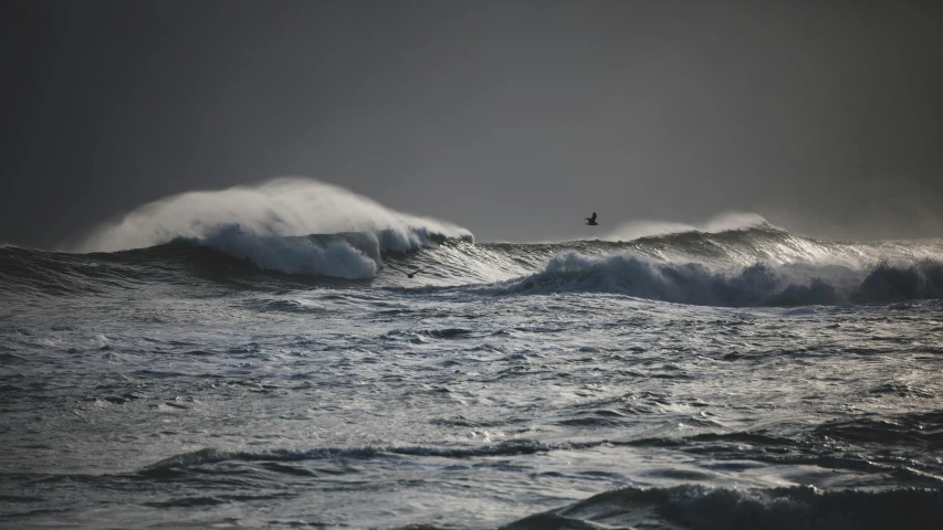 two large waves with one person surfing one wave