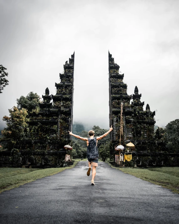 the woman in the dress is walking through a large gate