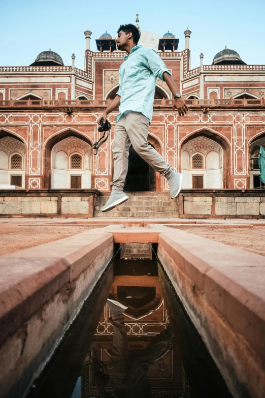 a man jumping into water near steps