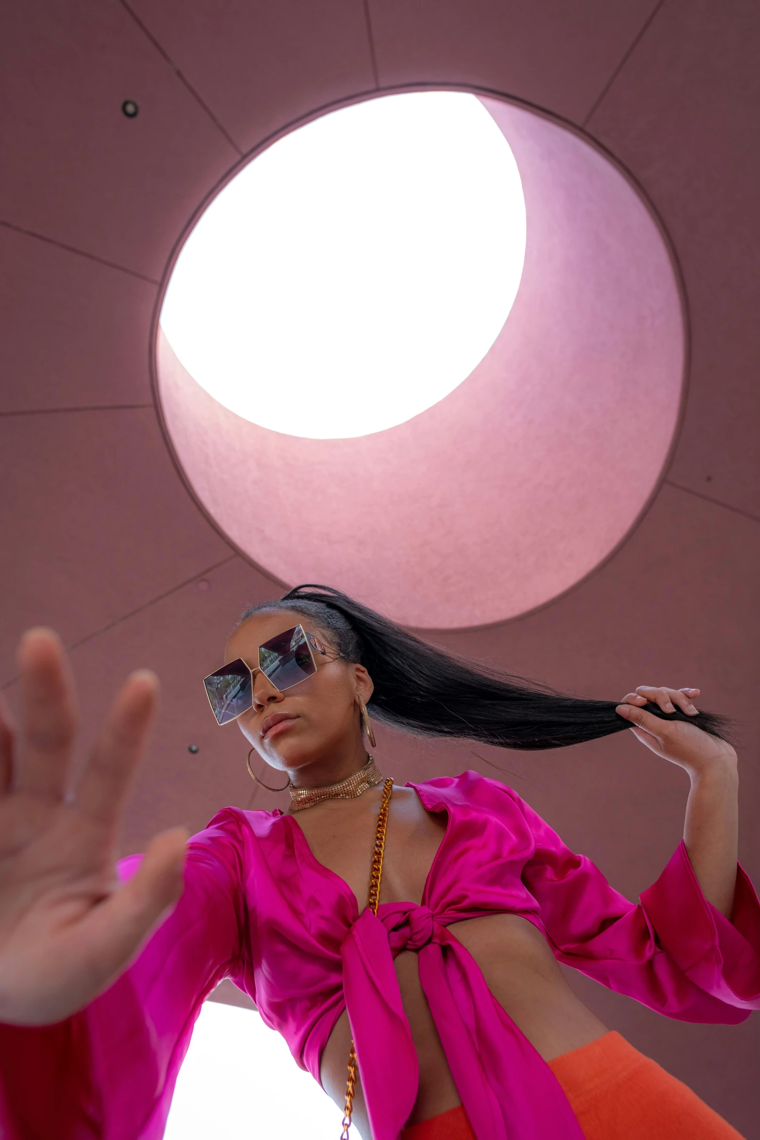 a woman wearing sunglasses has her hair in the air