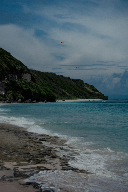 the beach has a parachute in the sky