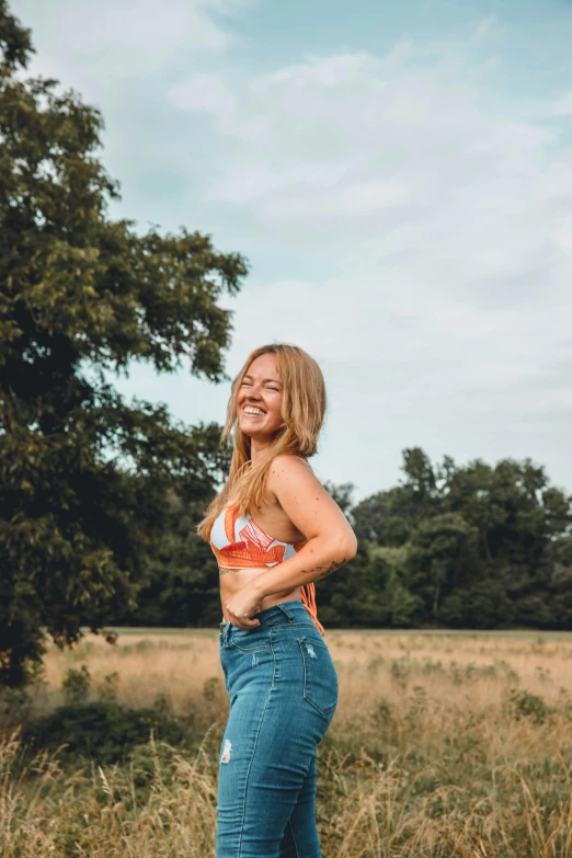 a woman posing with her arms folded out in front of trees