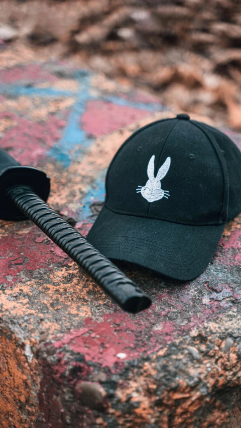 a hat sitting on top of a rock next to a black telephone