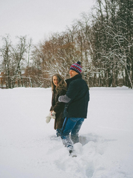 a man and woman walking through the snow