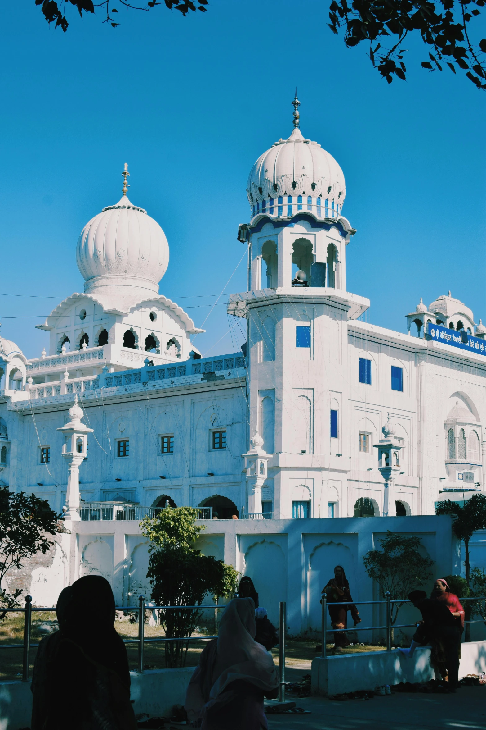 some people outside of a building with white buildings