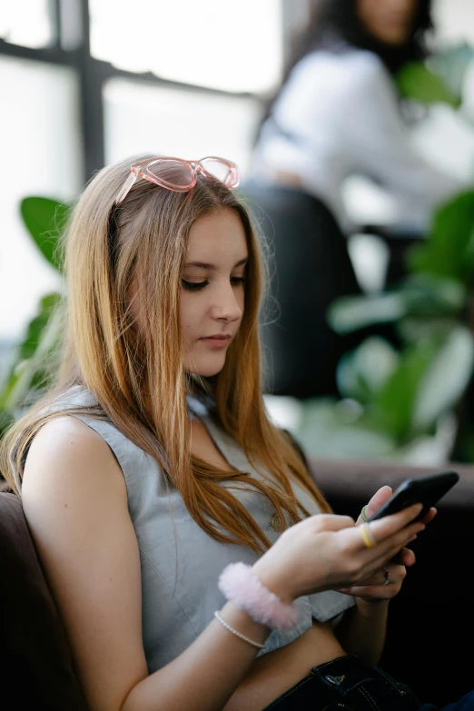 a woman sitting down using her cell phone