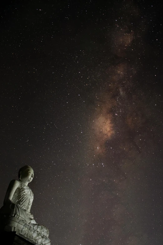 a statue is shown under the stars in the sky