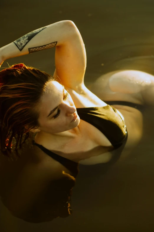 a woman with tattoos is swimming on her stomach