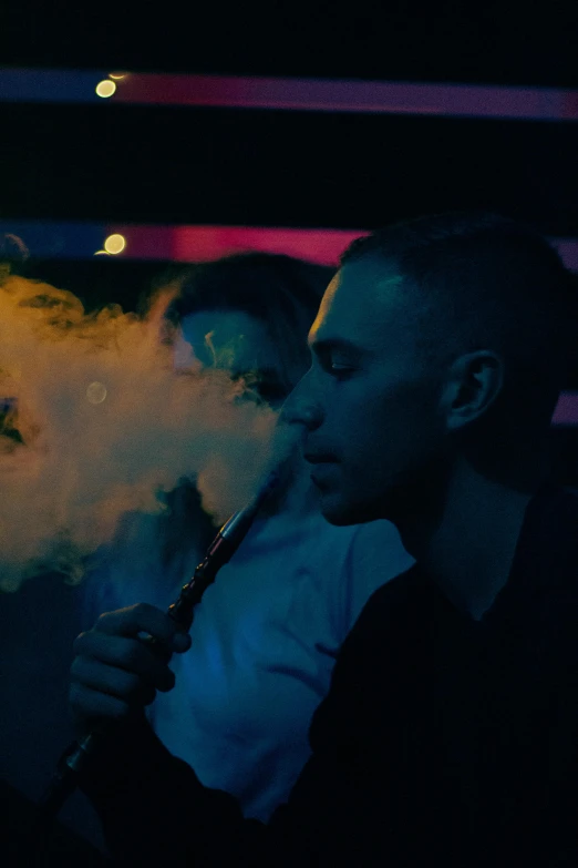 two people smoking and drinking a large bottle