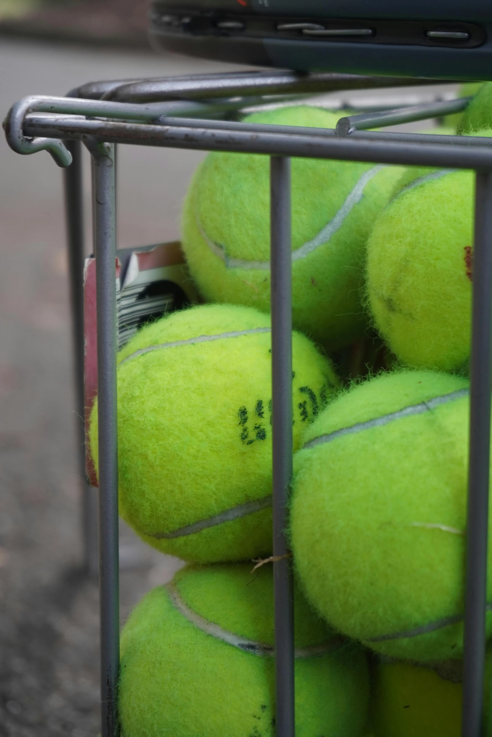 a rack holding tennis balls on the pavement