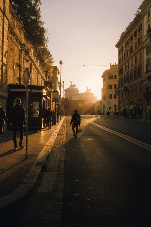 the sun rises and people walk down the street