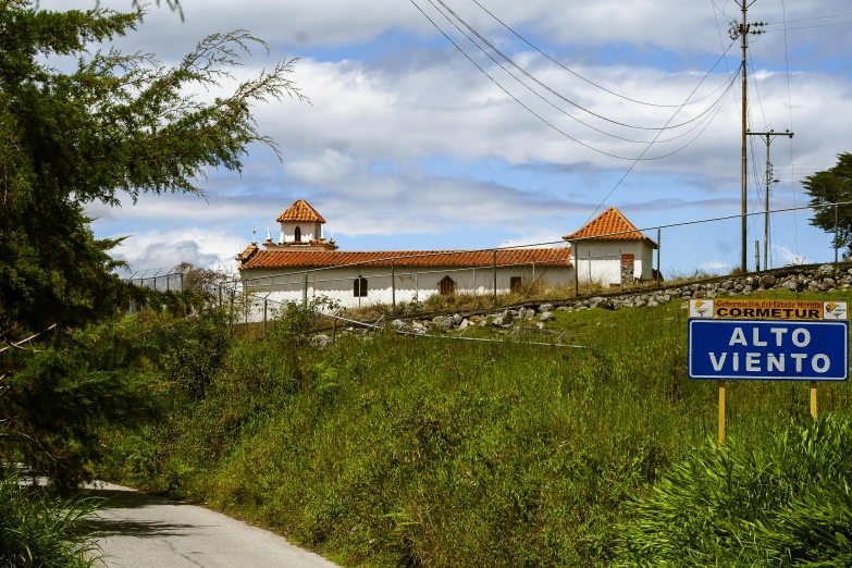 an old church with a blue sign sitting on the side