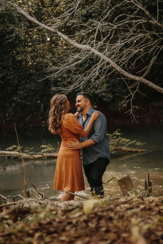 an engaged couple emcing and walking through some water