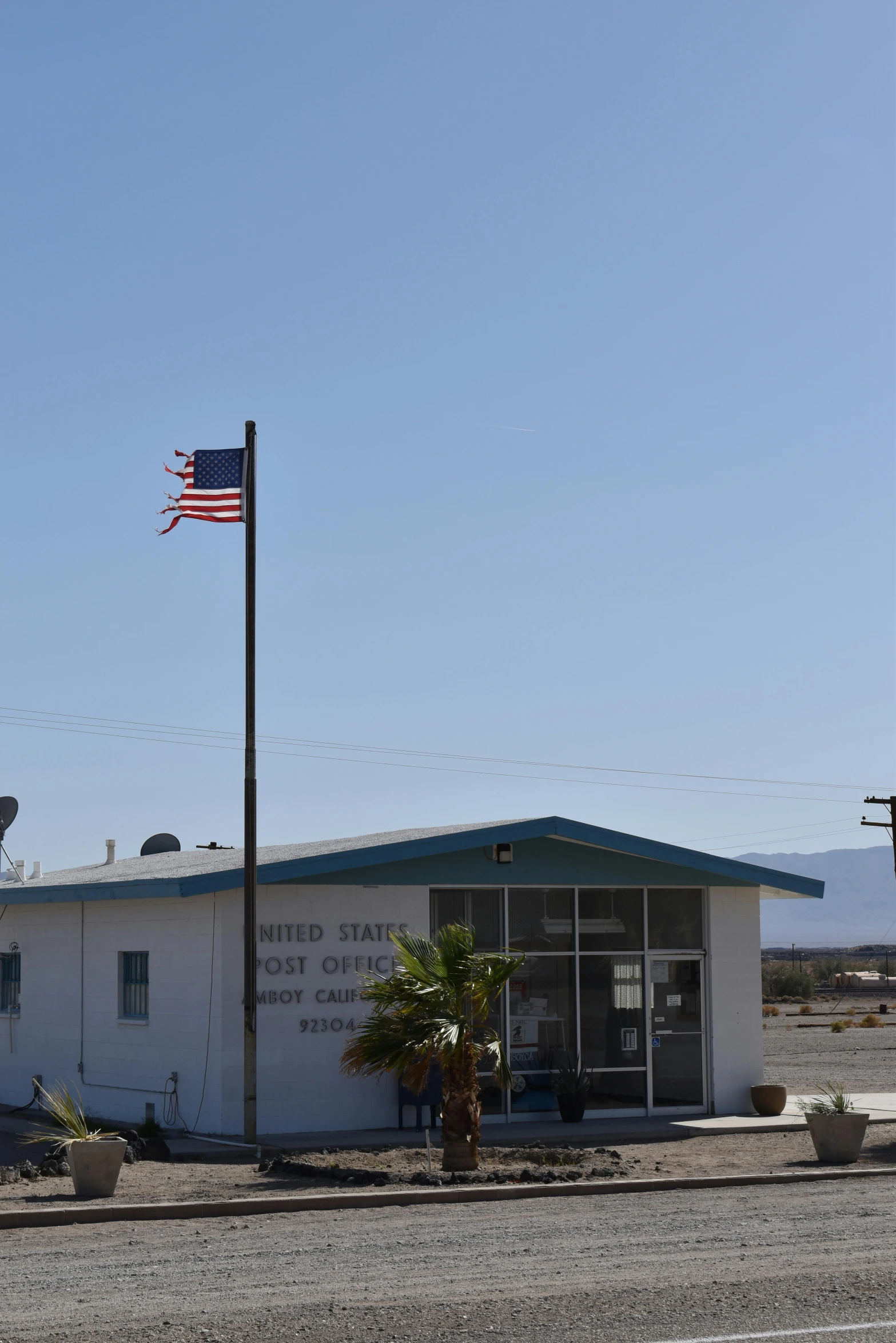 an airplane flies above a building with an american flag