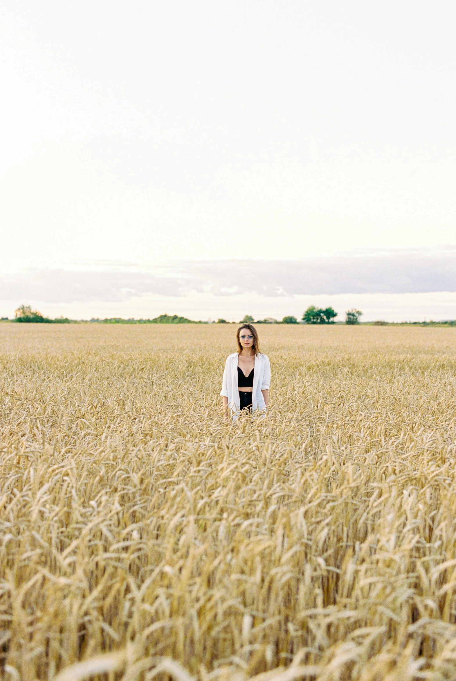 woman standing in middle of large field with blonde hair