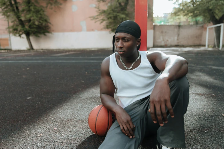 a black man posing for a po holding a basketball