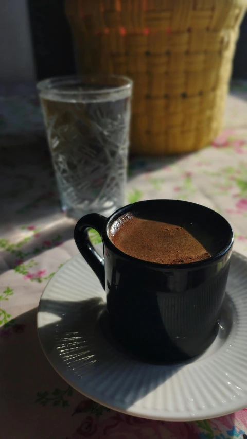 a cup and saucer on a table with water