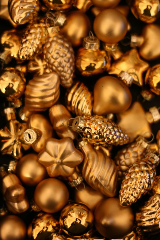 closeup image of gold christmas ornaments with pine cones
