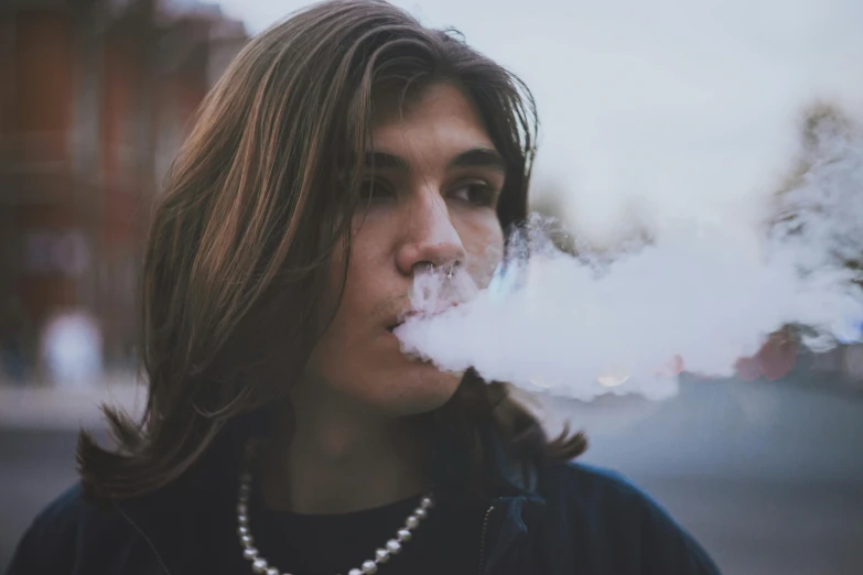 a woman standing outside and smoke coming out of her mouth