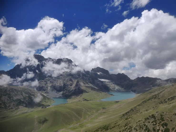 clouds floating over the mountain peaks with water below