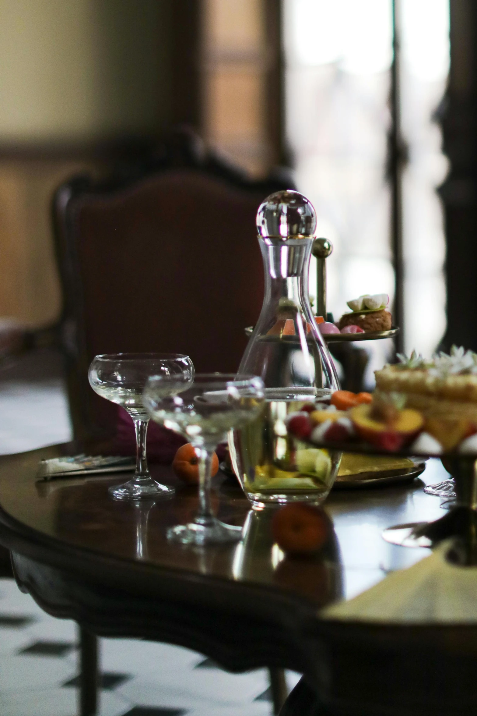 the glassware is on a wooden table with a bottle and glasses