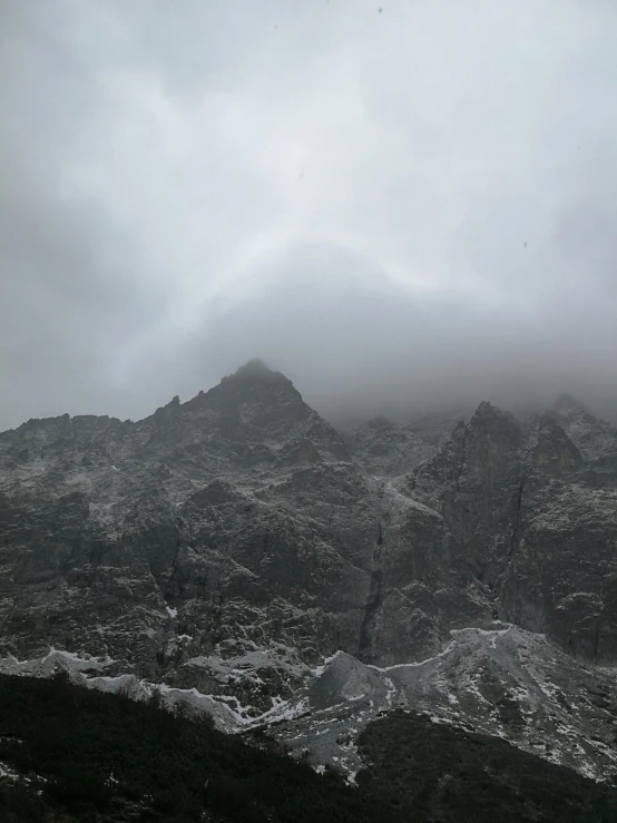 mountains covered with clouds and snow in a valley