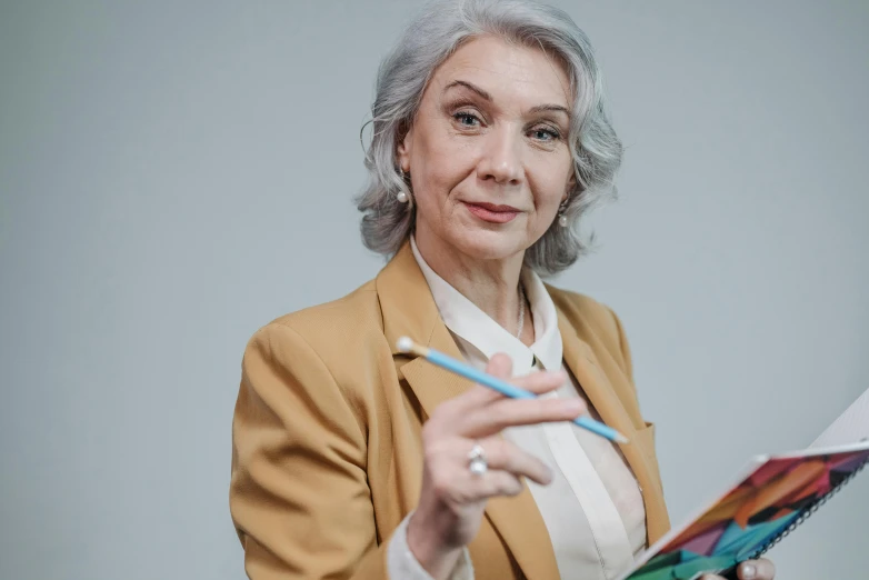 woman in golden jacket holding out scissors and piece of paper