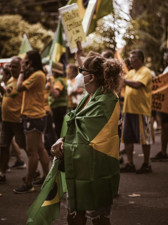 woman in green and yellow outfit standing on street holding signs