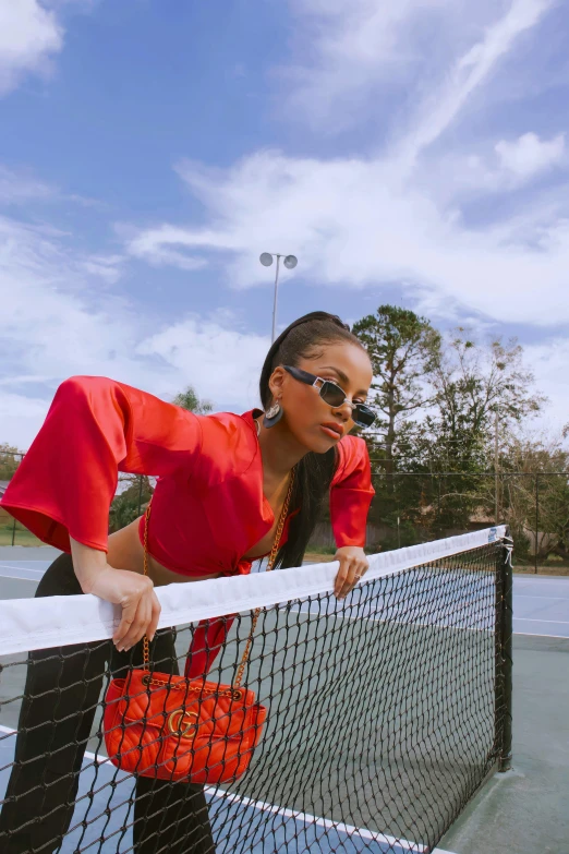 there is a woman standing at the net with a tennis racket