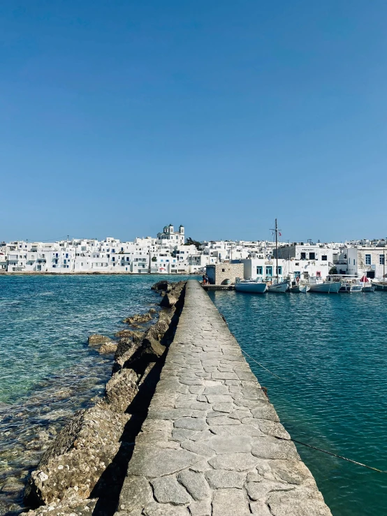 a long, concrete sidewalk leads out into the blue water