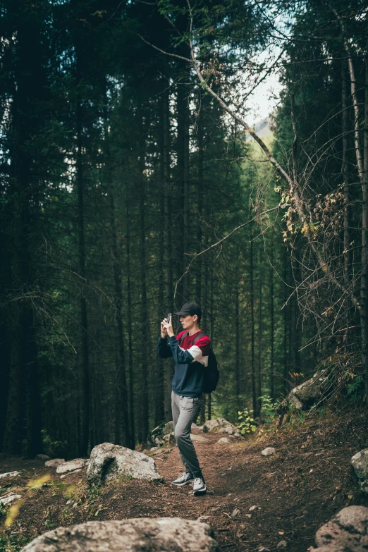 a man is standing on a path in the woods