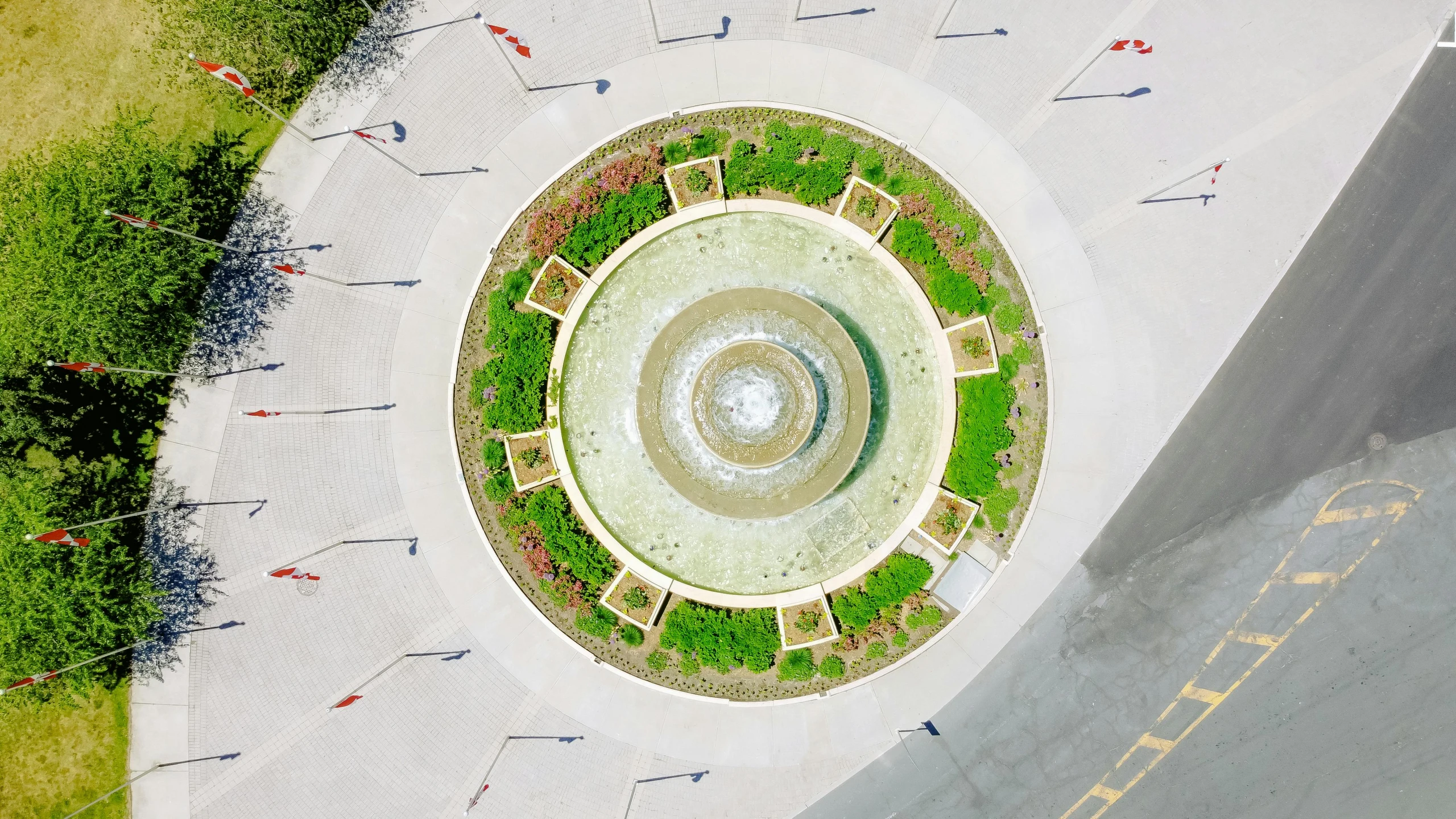 an aerial view of a circular fountain with landscaping