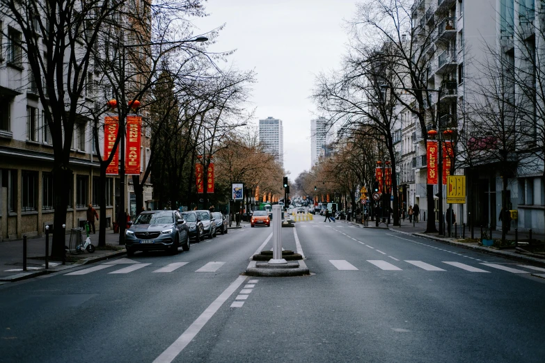 a dark, empty road with tall buildings and many cars