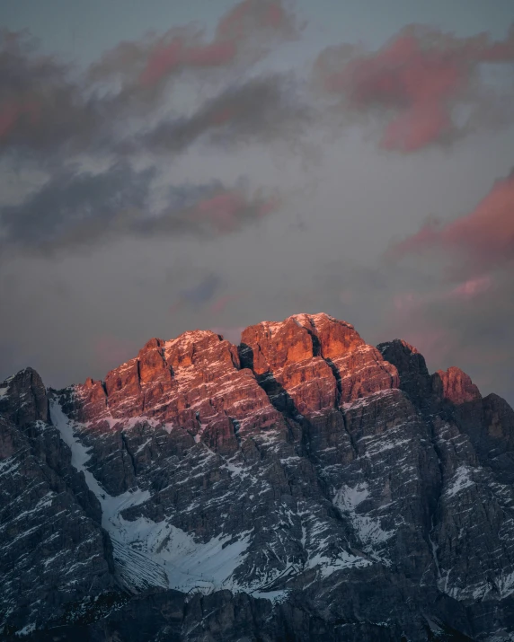 mountains rise in the foreground, as a twilight sky is partially cloudy