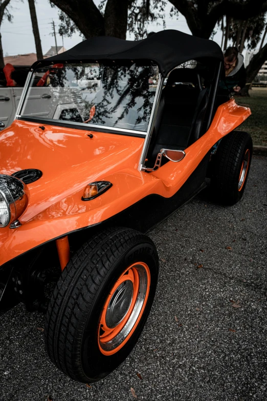 an orange and black car parked on the side of the street