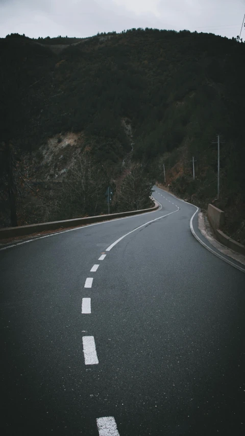 an empty road has a few curves on one side