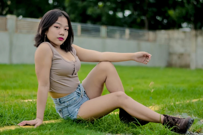 a beautiful young lady sitting on the grass