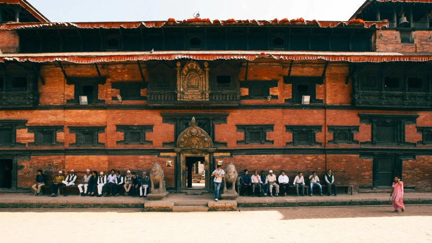 a group of people sitting in front of a building