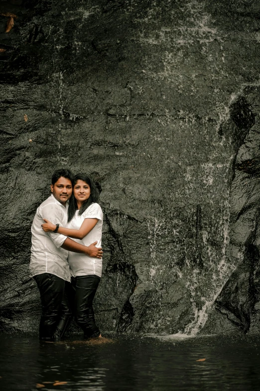 two people are hugging on the side of a wall