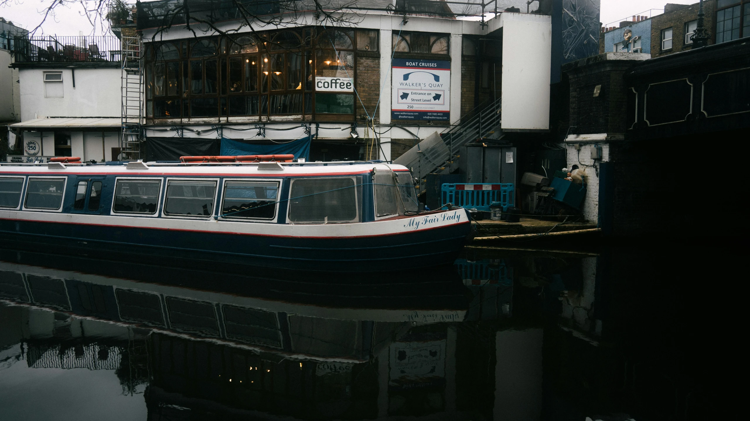 a large boat floating on a river past tall buildings