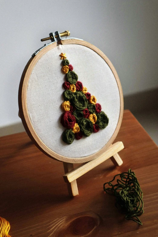 a colorful christmas tree on a cross stitch hoop