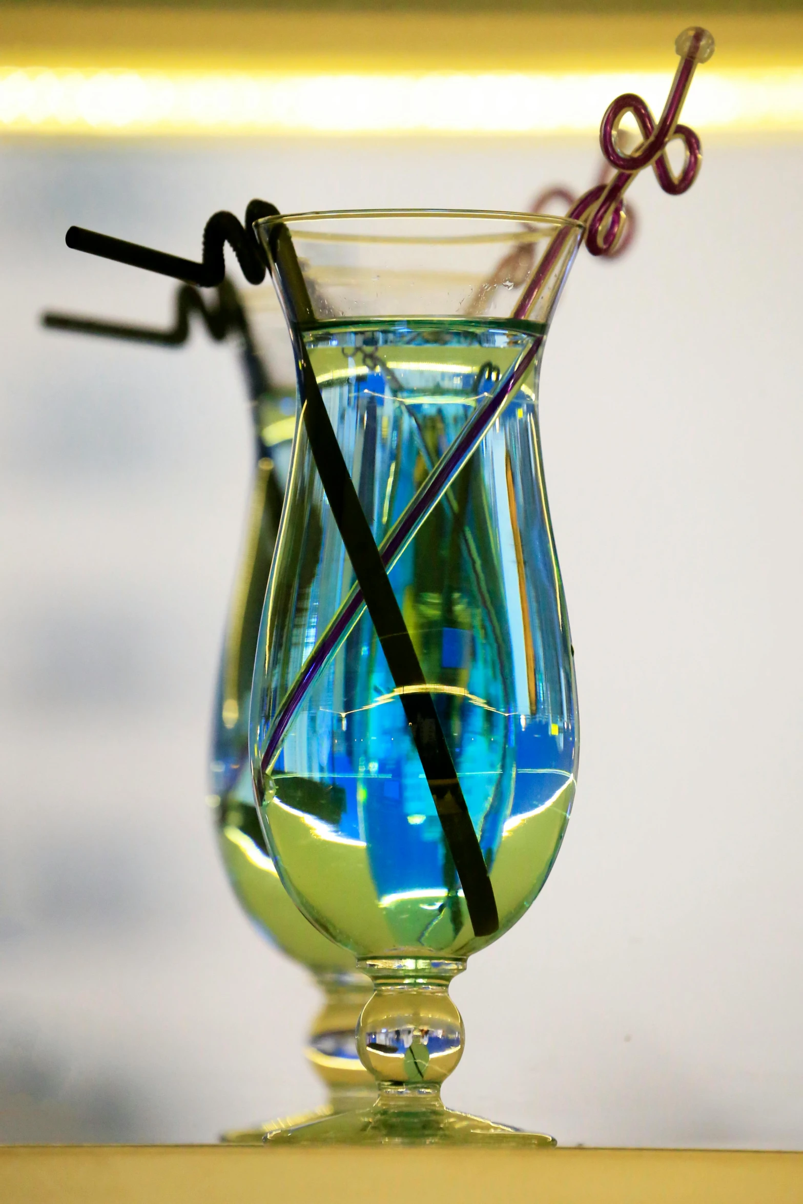 a small glass vase holding liquid and black sticks