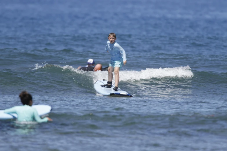 some young people on surf boards at the beach