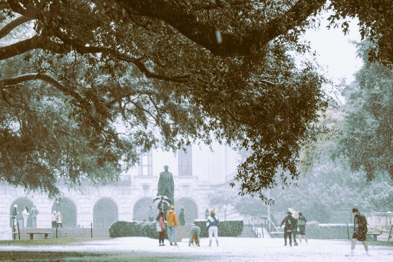 a group of people walk in front of a park in the winter